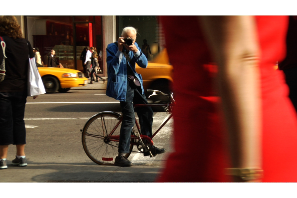 Bill photographing on the streets of Manhattan. A scene from BILL CUNNINGHAM NEW YORK. A Zeitgeist Films release.