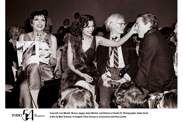 Liza Minelli, Bianca Jagger, Andy Warhol, and Halston at Studio 54. Photographer: Adam Scull. STUDIO 54. A film by Matt Tyrnauer. A Zeitgeist Films release in association with Kino Lorber.